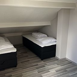 Gezellige slaapkamer in TXL Huisje 299, een vakantiehuis in De Cocksdorp op Texel, Waddeneilanden, met comfortabele bedden onder een schuin dak.
