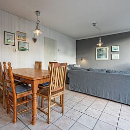 Gezellige woonkamer in Vakantiehuis Slufterhoek 114, De Cocksdorp, Texel, met comfortabele zithoek en eettafel.