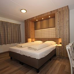 Stylish bedroom in Villa De Witte Hoek 138 conservatory, De Cocksdorp Texel, vacation home with wooden accents and cozy atmosphere.