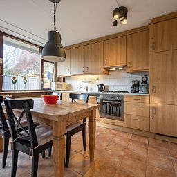Ruime keuken van Vakantiehuis Slufterhoek 100 in De Cocksdorp, Texel met houten kasten.