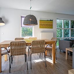 Gezellige eetruimte in Villapark Residentie Texel nr. 794, vakantiehuis in De Cocksdorp, Texel, met uitzicht op de groene tuin.