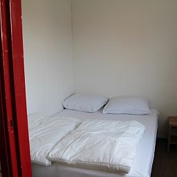 Sfeervolle slaapkamer in Onder de vuurtoren 115, Texel, De Cocksdorp met comfortabel tweepersoonsbed en nachtkastje.