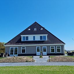 Vakantiehuis De Slufter in De Cocksdorp, Texel heeft een uitnodigend terras met comfortabele zitplaatsen voor ontspanning.