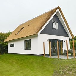 Zijaanzicht van De Postschipper vakantiehuis in De Cocksdorp, Texel, met ruime tuin.
