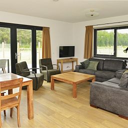 Gezellige woonkamer van De Postschipper vakantiehuis in De Cocksdorp, Texel, met uitzicht op de tuin.