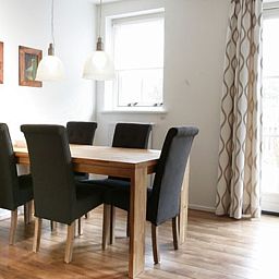 Eetkamer met houten tafel in Type 8 - 2108 vakantiehuis, De Cocksdorp, Texel, ideaal voor familiediners.