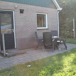 Terrace of Duin-/vuurtorenzicht detached vacation home in De Cocksdorp, Texel with garden chairs and table.