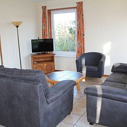 Cozy living room of Duin-/vuurtorenzicht detached vacation home in De Cocksdorp, Texel with comfortable sofas.
