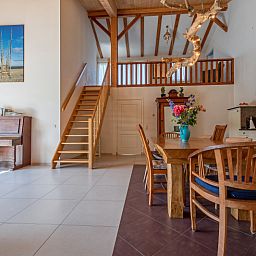 Open leefruimte met houten trap in Vakantiehuis Paal 86, De Cocksdorp, Texel.