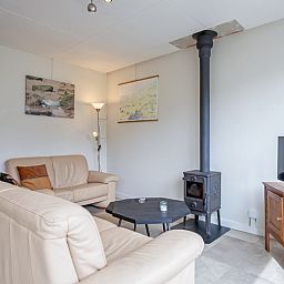 Comfortabele woonkamer van Vakantiehuis Slufterhoek 118 in Texel met houtkachel en moderne inrichting.