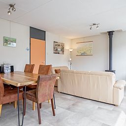 Ruime eetkamer in Vakantiehuis Slufterhoek 118, Texel, met houten tafel en comfortabele stoelen.