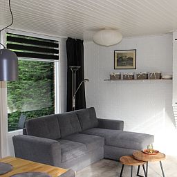 Moderne woonkamer in Bungalow Tamarisk 164 - Bartje, De Cocksdorp, Texel met comfortabele zithoek.