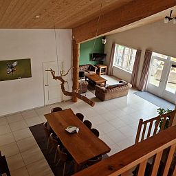 Geraeumiges Wohnzimmer in Cottage in De Cocksdorp, Texel mit Holzinterieur und grossen Fenstern, ideales Ferienhaus auf den Watteninseln.