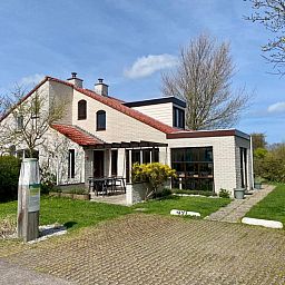 Vakantiehuis D 491 in De Cocksdorp, Texel, omgeven door groene natuur, met een uitnodigend terras voor een ontspannen verblijf op de Waddeneilanden.