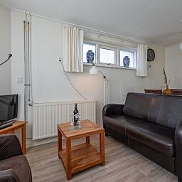 Gemuetliches Wohnzimmer im Ferienhaus Kikkertstraat 60, De Cocksdorp, Texel mit bequemer Sitzgelegenheit.