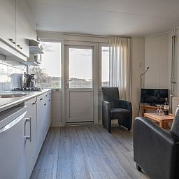 Moderne Kueche im Ferienhaus Kikkertstraat 60, De Cocksdorp, Texel mit Blick auf die Landschaft.