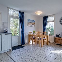 Ruime eetkamer met uitzicht op de tuin in Vakantiehuis Slufterduin 52a, De Cocksdorp, Texel.