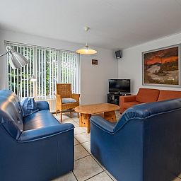Gemuetliches Wohnzimmer im Ferienhaus Slufterduin 098, De Cocksdorp, Texel mit bequemen Sofas.
