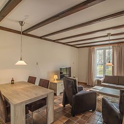 Gezellige woonkamer in Type R vakantiehuis, De Cocksdorp, Texel, met grote ramen en comfortabele zitplaatsen.