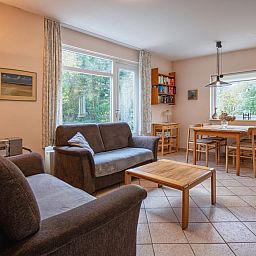 Cozy living room of Holiday home Slufterduin 094 in De Cocksdorp, Texel. Comfortable seating area overlooking the green surroundings.
