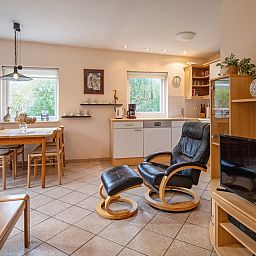 Cozy living room in Holiday home Slufterduin 094, De Cocksdorp, Texel. Comfortable seating area and modern kitchen in a cozy environment.