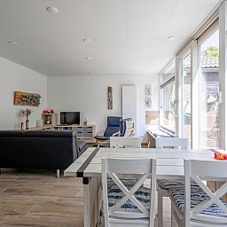 Lichte woonkamer van Vakantiehuis Slufterhoek 158 in De Cocksdorp, Texel, met moderne inrichting en uitzicht op de tuin.