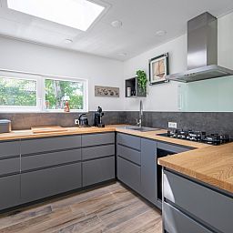 Moderne keuken in Vakantiehuis Slufterhoek 158, De Cocksdorp, Texel. Ruime inrichting met houten werkblad en veel natuurlijk licht.