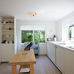 Ruime keuken in Bungalow Schelpenoord - Vakantiehuis De Oester, De Cocksdorp, Texel, met houten werkblad en veel daglicht.