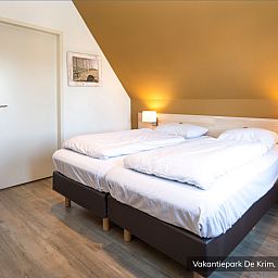 Cozy bedroom in Family Villa 16 persons, De Cocksdorp, Texel with comfortable beds.