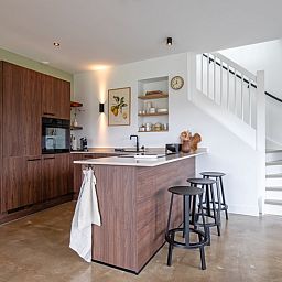 Stijlvolle keuken met bar in Vakantiehuis Het Rif, De Cocksdorp, Texel. Perfect voor kookliefhebbers op de Waddeneilanden.