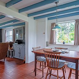 Eetkamer in vakantiehuis Muyweg 062, De Cocksdorp, Texel met houten tafel en stoelen voor gezellige maaltijden.