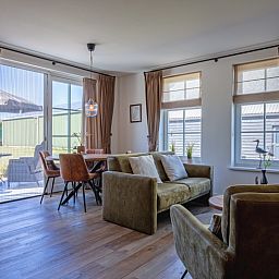 Lichte binnenruimte van Appartement B, vakantiewoning in De Cocksdorp, Texel, met eethoek.