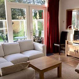 Zonnige woonkamer met uitzicht op de tuin in Vakantiehuis Slufteroord 270, Bungalowpark Slufteroord, Texel.