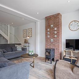 Gezellige woonkamer van Vakantiehuis Slufterhoek 104 in De Cocksdorp, Texel met comfortabele zitplaatsen en sfeervolle inrichting.