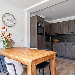Moderne keuken in Vakantiehuis Slufterhoek 104, De Cocksdorp, Texel met houten eettafel en stijlvolle inrichting.