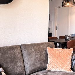 Gezellige woonkamer van Vakantiehuisje in De Cocksdorp, Texel met comfortabele bank en eethoek, ideaal voor een ontspannen vakantie.