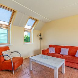 Gezellige woonkamer van Vakantiehuisje in De Cocksdorp, Texel met comfortabele zitruimte en veel natuurlijk licht door dakramen.