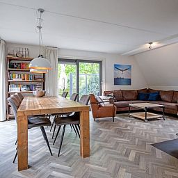 Ruime woonkamer van Vakantiehuis in De Cocksdorp, Texel met comfortabele zithoek en eethoek, ideaal voor ontspanning op de Waddeneilanden.