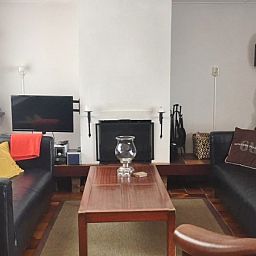 Gezellige woonkamer van Bungalow Slufterduin - De Blauwe Skor in De Cocksdorp, Texel, met comfortabele zithoek en open haard.