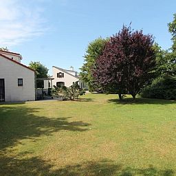 Ruime tuin bij Vakantiehuis D 503 in De Cocksdorp, Texel, omringd door groene natuur en rustgevende omgeving op de Waddeneilanden.