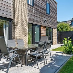 Geniet van de zonnige tuin en het terras van Vakantiehuis A 103 in De Cocksdorp, Texel, ideaal voor een ontspannen verblijf op de Waddeneilanden.