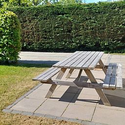 Geniet van de buitenruimte bij Vakantiehuis B 223 in De Cocksdorp, Texel, met een uitnodigend terras en picknicktafel voor ontspanning.