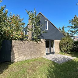 Vakantiehuis A 343 in De Cocksdorp, Texel, biedt een serene buitenruimte met terras, omgeven door groene natuur op de Waddeneilanden.