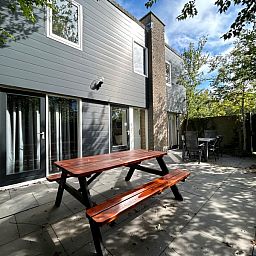 Ontspan op het ruime terras van Vakantiehuis A 343 in De Cocksdorp, Texel, omgeven door de serene natuur van de Waddeneilanden.