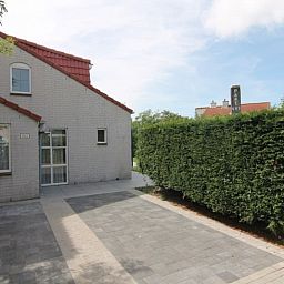 Vakantiehuis D 493 in De Cocksdorp, Texel met ruime oprit en groene haag, perfect voor een ontspannen verblijf op de Waddeneilanden.