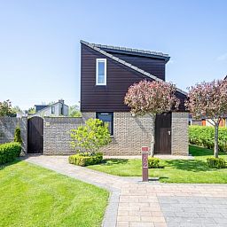 Vacation home A 309 in De Cocksdorp, Texel, offers a charming outdoor space with green garden and modern architecture on the Wadden Islands.