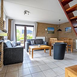 Cozy living room of Holiday home A 309 in De Cocksdorp, Texel, with comfortable seating area and garden view.