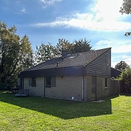 Vakantiehuis A 023 in De Cocksdorp, Texel, omgeven door groen en zonlicht, ideaal voor een ontspannen verblijf op de Waddeneilanden.