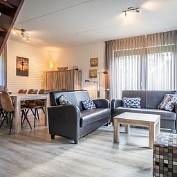Gezellige woonkamer van Vakantiehuis C 137 in De Cocksdorp, Texel, met comfortabele zithoek en eetgedeelte voor een ontspannen verblijf.