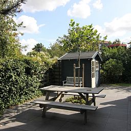 Geniet van de zonnige tuin met picknicktafel bij Vakantiehuis A 345 in De Cocksdorp, Texel. Perfect voor ontspannen buitenmomenten.